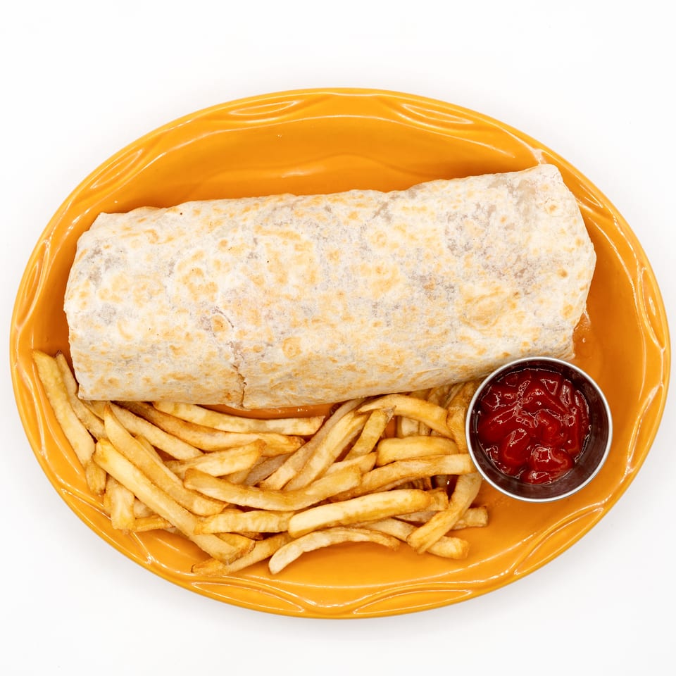 Burrito served with golden French fries and a cup of ketchup on an orange oval plate.